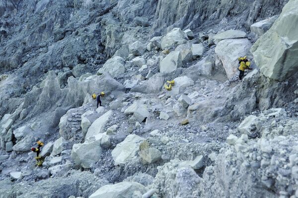  Thợ mỏ khuân vác túi lưu huỳnh từ mỏ đá trên núi lửa Kawah Ijen đang hoạt động ở Indonesia - Sputnik Việt Nam