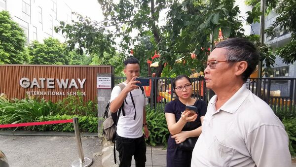 Phóng viên phỏng vấn người dân tại cổng trường Quốc tế Gateway.  - Sputnik Việt Nam