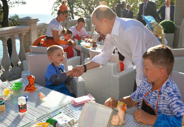 Tổng thống Nga Vladimir Putin trong cuộc gặp tại Sochi với con cái các gia đình bị ảnh hưởng lũ lụt ở tỉnh Irkutsk  - Sputnik Việt Nam