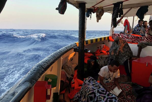 Người di cư đọc kinh Cô-ran trên tàu cứu hộ Tây Ban Nha Open Arms ở biển Địa Trung Hải - Sputnik Việt Nam