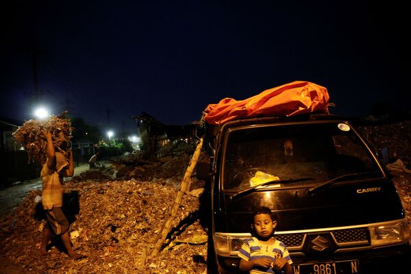 Đứa trẻ chờ người lớn tải rác ở làng Bangun, Indonesia - Sputnik Việt Nam
