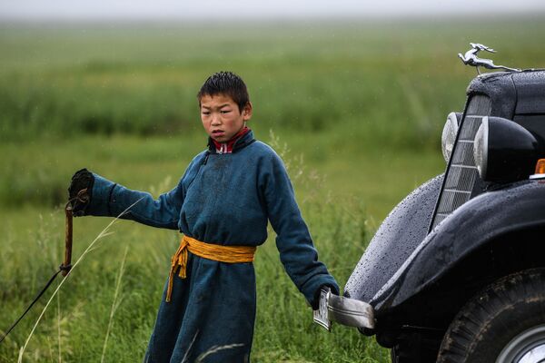 Một cậu bé bên cạnh chiếc xe GAZ-M1 trên cánh đồng ở quận Omnodelger thuộc tỉnh Khentii, Mông Cổ - Sputnik Việt Nam