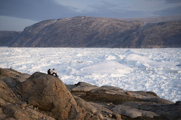 Sinh viên Đại học New York ngồi trên vách đá nhìn xuống sông băng Helheim ở Greenland - Sputnik Việt Nam