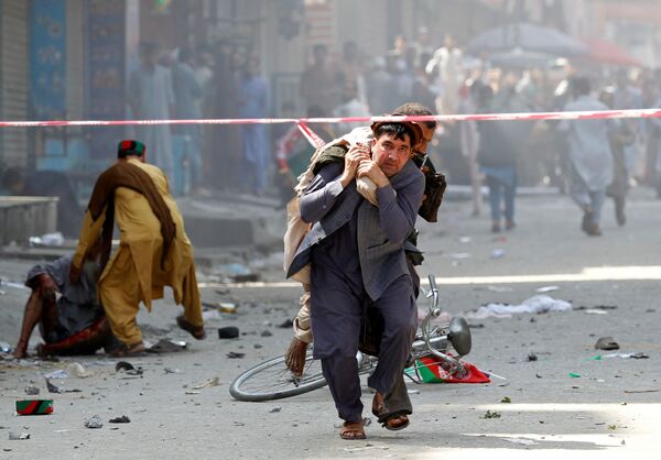 Một người đàn ông bế nạn nhân bị thương đến bệnh viện sau vụ nổ ở Jalalabad, Afghanistan - Sputnik Việt Nam