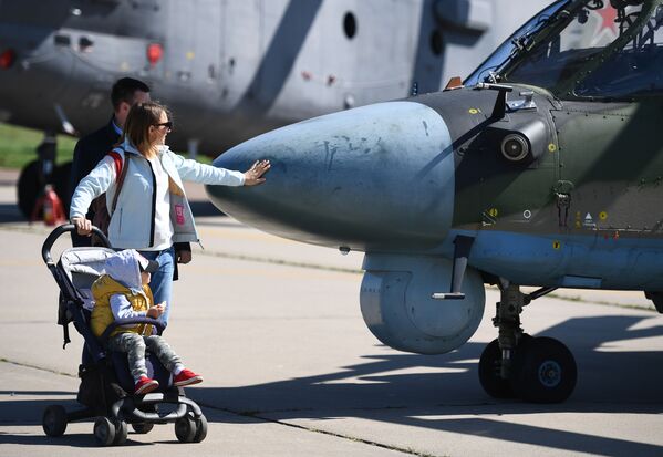 Một cặp vợ chồng cùng đứa con bên chiếc trực thăng quân sự Ka-52 Alligator tại Triển lãm Hàng không và Vũ trụ Quốc tế MAKS-2019 - Sputnik Việt Nam