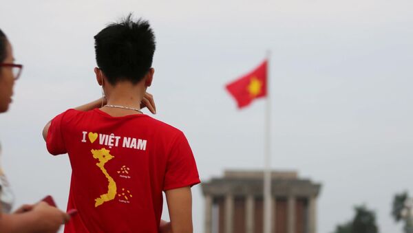 Một thanh niên mặc áo in hình Tổ quốc, ngắm nhìn lá Quốc kỳ trên Quảng trường Ba Đình, sáng 2/9/2019.  - Sputnik Việt Nam
