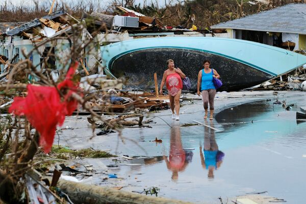 Phụ nữ đi bộ qua đống đổ nát sau cơn bão Dorian trên đảo Great Abaco ở Marsh Harbor, đảo Bahamas - Sputnik Việt Nam