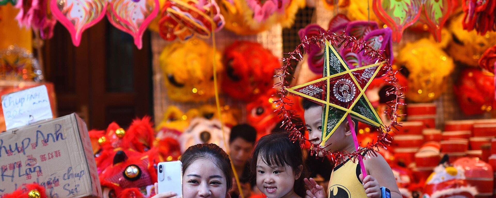 Một người phụ nữ Việt Nam chụp ảnh tự sướng cùng hai con ở khu phố cổ Hà Nội trước thềm Lễ hội Trung thu sắp tới. - Sputnik Việt Nam, 1920, 13.09.2019