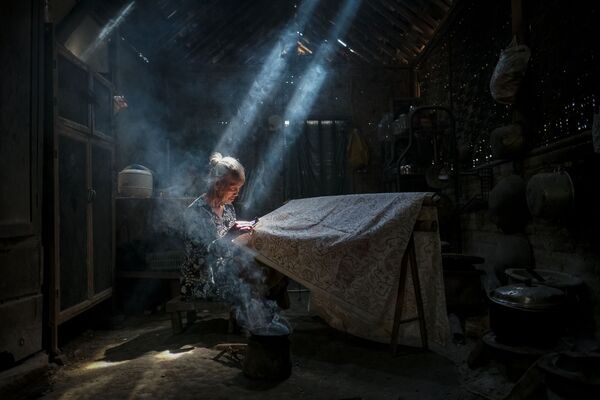 Bức ảnh Under the light making batik crafts (Soi bóng nắng dệt vải Batik) của nhiếp ảnh gia Indonesia Bimo Pradityo, tham gia cuộc thi ảnh AGORA Awards 2019 - Sputnik Việt Nam