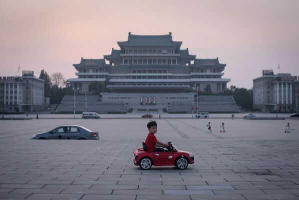 Cậu bé trong chiếc ô tô đồ chơi trên quảng trường Kim Nhật Thành ở Bình Nhưỡng, Bắc Triều Tiên - Sputnik Việt Nam