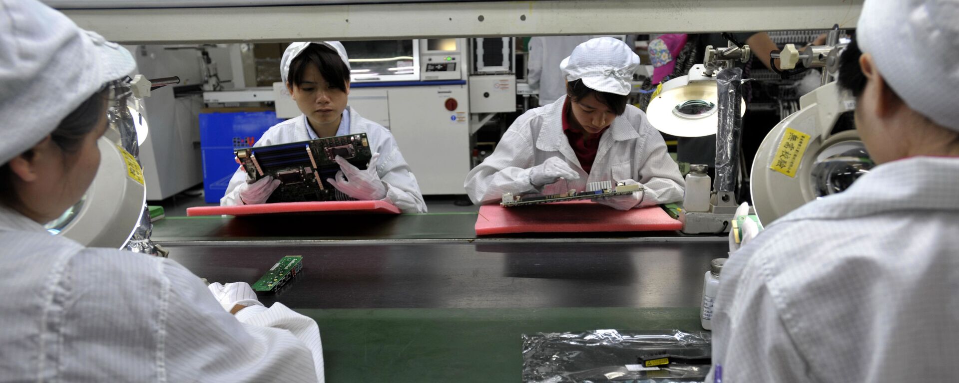 Công nhân Trung Quốc lắp ráp linh kiện điện tử trong nhà máy thuộc công ty khổng lồ Foxconn của Đài Loan tại Thâm Quyến, Trung Quốc - Sputnik Việt Nam, 1920, 26.11.2020