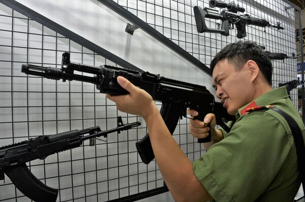 Một du khách xem xét khẩu súng trường tấn công Kalashnikov AK-204 tại Triển lãm Quốc phòng & An ninh Việt Nam 2019 Hà Nội - Sputnik Việt Nam
