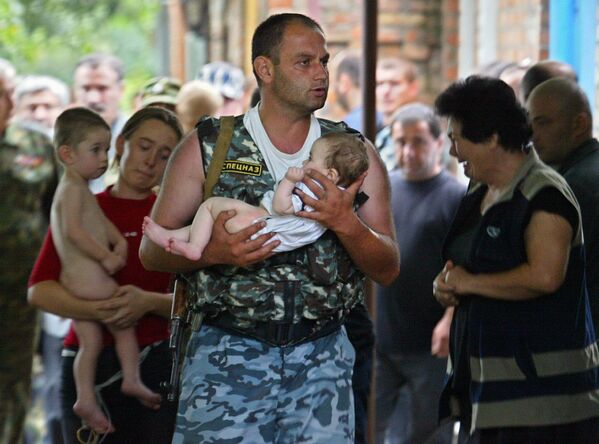 Lính đặc nhiệm bế đứa trẻ sau khi giải cứu trường học ở Beslan khỏi nhóm khủng bố bắt con tin - Sputnik Việt Nam