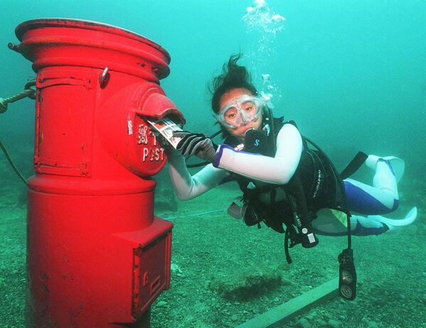 Một thợ lặn đặt lá thư nhựa vào hộp thư được đặt ở độ sâu 10 mét dưới đáy biển ngoài khơi bờ biển Suzami ở tỉnh Wakayama - Sputnik Việt Nam