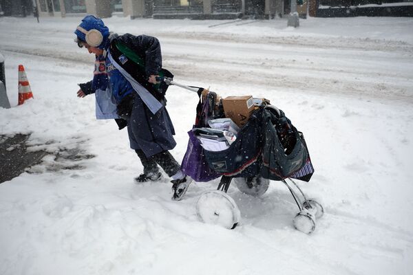 Nữ nhân viên bưu điện kéo xe đẩy trên đường phố đầy tuyết ở New York dưới cơn bão tuyết - Sputnik Việt Nam
