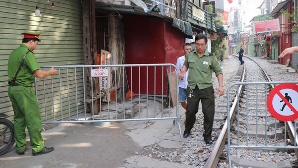 Lực lượng chức quận Hoàn Kiếm đặt barie ngăn không cho khách du lịch vào khu vực cà phê đường tàu. - Sputnik Việt Nam