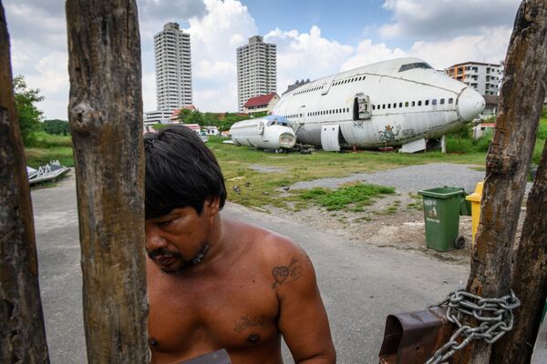Một người đàn ông ở cổng trước chiếc máy bay bị bỏ hoang ở ngoại ô Bangkok - Sputnik Việt Nam