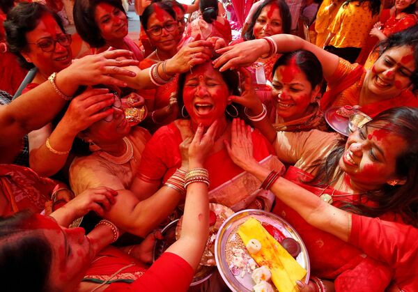 Vẽ bột màu lên khuôn mặt người phụ nữ Ấn Độ để tôn vinh nữ thần Hindu Durga tại lễ hội Durga Puja ở Chandigarh, Ấn Độ - Sputnik Việt Nam