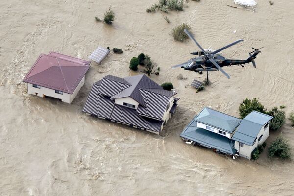 Máy bay trực thăng trên các khu dân cư bị ngập lụt bởi sông Chikuma sau cơn bão Hagibis ở Nagano, miền trung Nhật Bản - Sputnik Việt Nam