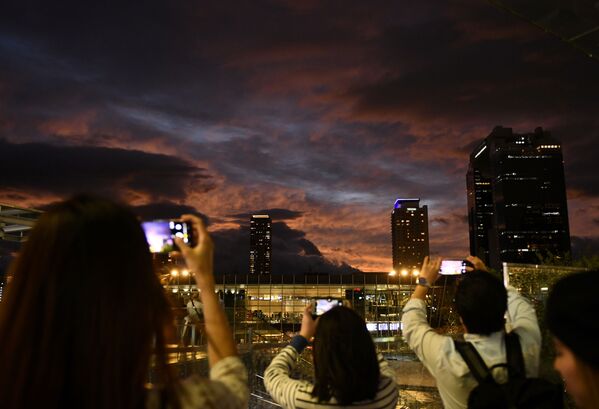 Người dân chụp ảnh bầu trời hoàng hôn khi bão Hagibis đến Osaka, Nhật Bản - Sputnik Việt Nam