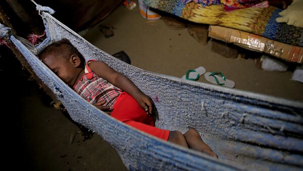 Một bé gái ngủ trên võng và chị gái ngủ trên giường tạm thời gần đó, Hodeidah, Yemen - Sputnik Việt Nam