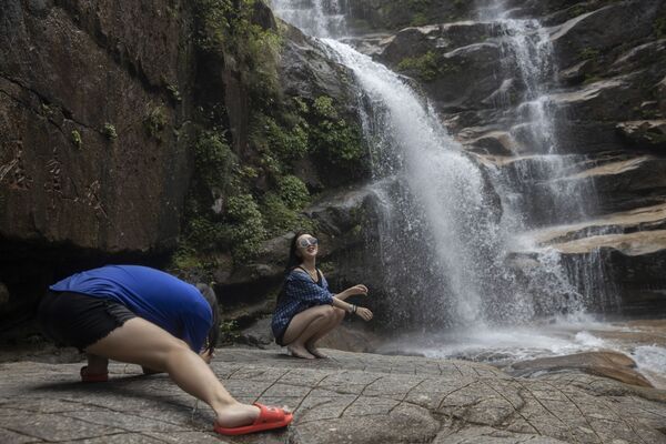 Người phụ nữ tạo dáng chụp ảnh tại thác nước ở Vũ Di Sơn, tỉnh Phúc Kiến, miền đông Trung Quốc - Sputnik Việt Nam