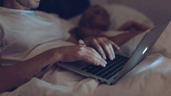 Мужчина с ноутбуком ночью в постели - Sputnik Việt Nam