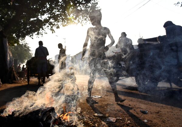 Người dân đi ngang qua đống rác cháy ở Kolkata, Ấn Độ - Sputnik Việt Nam