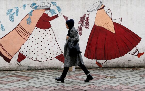 Người phụ nữ đi ngang qua bức tường với tranh ở Tehran, Iran - Sputnik Việt Nam