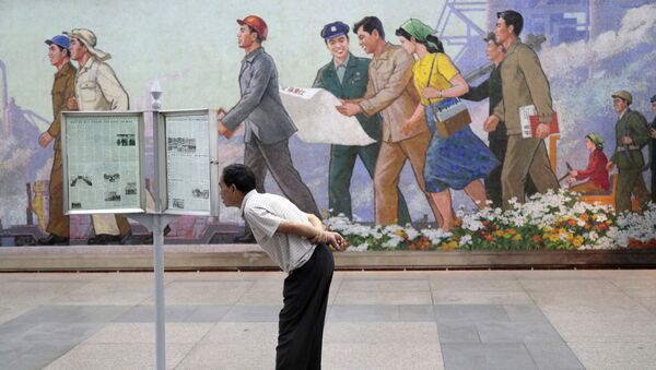 Hành khách tàu điện ngầm Bình Nhưỡng đứng đọc báo tường - Sputnik Việt Nam