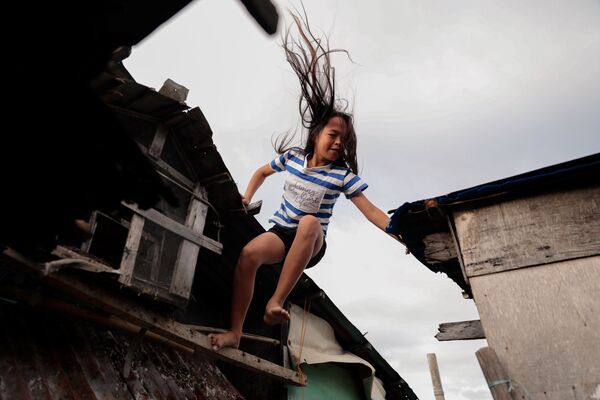 Cindy Martinez trên mái của túp lều gia đình ở làng Sitio Pariahan, Philippines - Sputnik Việt Nam