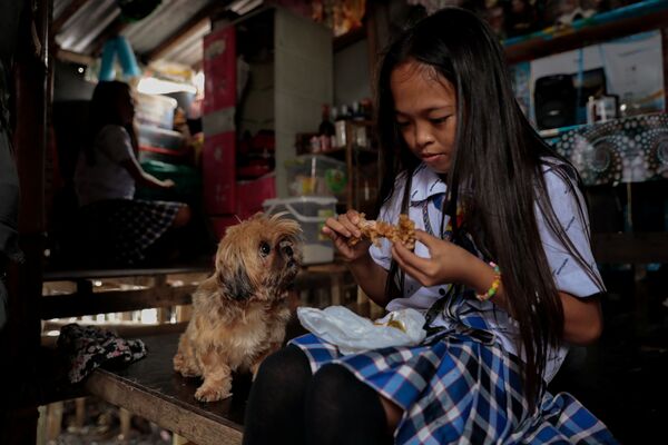 Cindy Martinez với chú chó trong ngôi nhà của gia đình ở làng Sitio Pariahan, Philippines - Sputnik Việt Nam