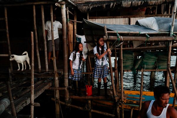 Chị em Cindy và Danica Martinez chuẩn bị lên thuyền đi học từ ngôi làng bị ngập ở Sitio Pariahan, Philippines - Sputnik Việt Nam