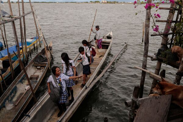 Chị em Cindy và Danica Martinez đi học về bằng thuyền, trở lại ngôi làng bị ngập Sitio Pariahan - Sputnik Việt Nam
