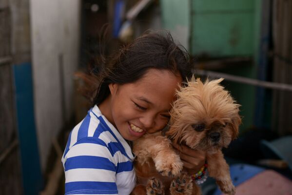 Cô bé với chú chó từ ngôi làng bị ngập Sitio Pariahan, Philippines - Sputnik Việt Nam