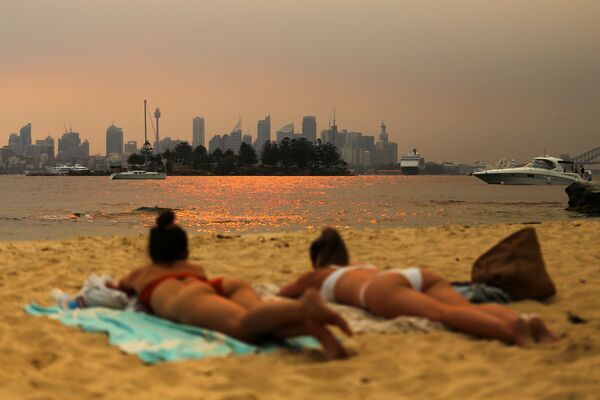 Các cô gái tắm nắng trên bãi biển giữa làn khói từ đám cháy rừng ở Úc - Sputnik Việt Nam