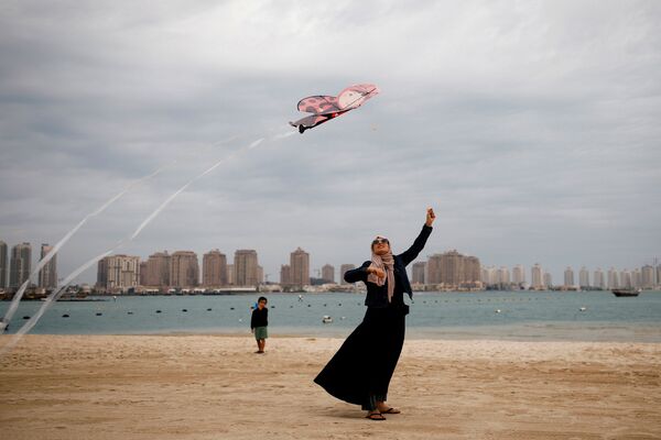 Người phụ nữ Hồi giáo với chiếc diều bay trên bãi biển ở Doha, Qatar - Sputnik Việt Nam
