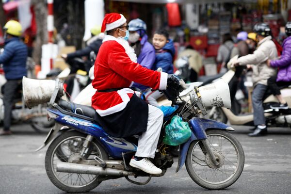 Người đàn ông mặc trang phục ông già Noel đi xe máy ở trung tâm Hà Nội - Sputnik Việt Nam