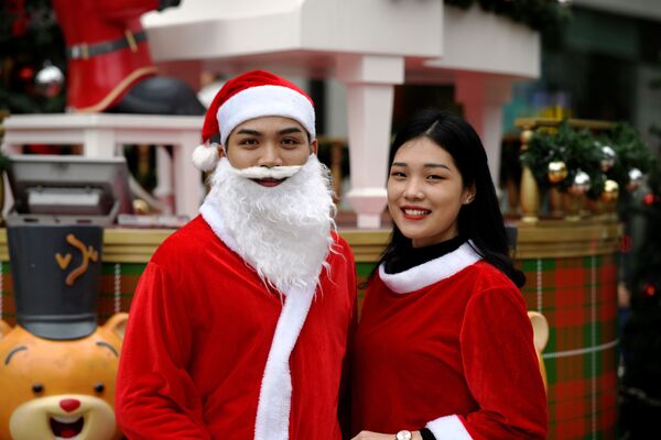 Đôi trai gái mặc trang phục ông già Noel ở trung tâm Hà Nội - Sputnik Việt Nam