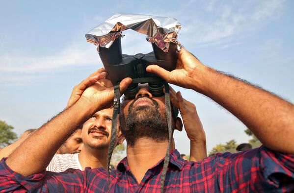 Người đàn ông quan sát nhật thực vòng lửa ở Ấn Độ bằng ống nhòm phủ phim - Sputnik Việt Nam