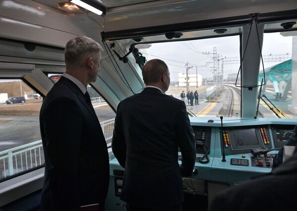 Tổng thống Nga Vladimir Putin bên trong buồng lái chuyến tàu đầu tiên khai trương tuyến đường sắt cầu Crưm - Sputnik Việt Nam