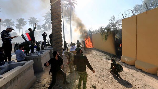 Người tham gia biểu tình đốt cháy cổng Đại sứ quán Mỹ ở Iraq. - Sputnik Việt Nam