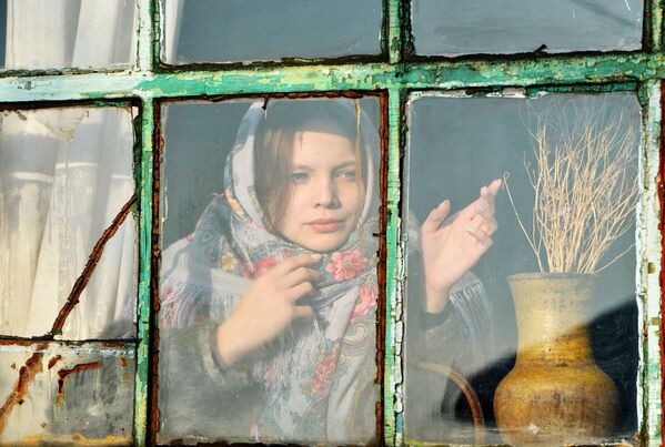 Cô gái nhìn ra cửa sổ trong buổi bói Giáng sinh ở làng Cossack Chernorechye, tỉnh Chelyabinsk - Sputnik Việt Nam