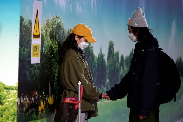 Cặp đôi đeo khẩu trang ở sân bay Phố Đông (Thượng Hải) - Sputnik Việt Nam