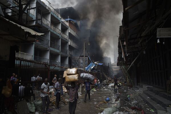 Người dân chở hàng hóa cứu được sau đám cháy trong khu vực chợ Balogun ở Lagos - Sputnik Việt Nam