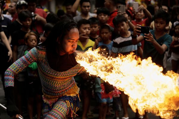 Nữ nghệ sĩ đường phố phun lửa từ miệng trong lễ đón Tết âm lịch tại Manila, Philippines. - Sputnik Việt Nam