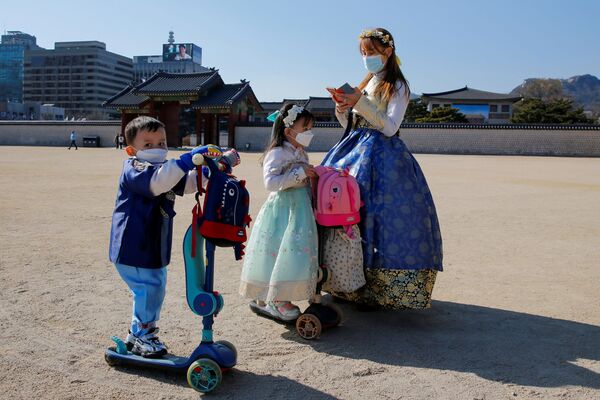Người phụ nữ và các con đeo khẩu trang bảo vệ ở Seoul - Sputnik Việt Nam