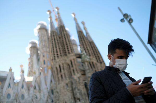 Du khách mang khẩu trang trên cảnh nền Sagrada Familia - Sputnik Việt Nam