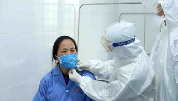 Trong ảnh: Bác sĩ Đội cơ động Bệnh viện Bạch Mai (Hà Nội) thăm khám bệnh nhân dương tính với vi rút Corona tại Trung tâm y tế huyện Bình Xuyên (Vĩnh Phúc). Ảnh: Hoàng Hùng - TTXVN - Sputnik Việt Nam