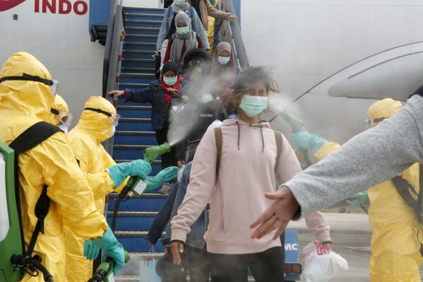 Các bác sĩ phun thuốc sát trùng cho các công dân Indonesia trở về từ Vũ Hán, Trung Quốc, trung tâm dịch virus Corona - Sputnik Việt Nam